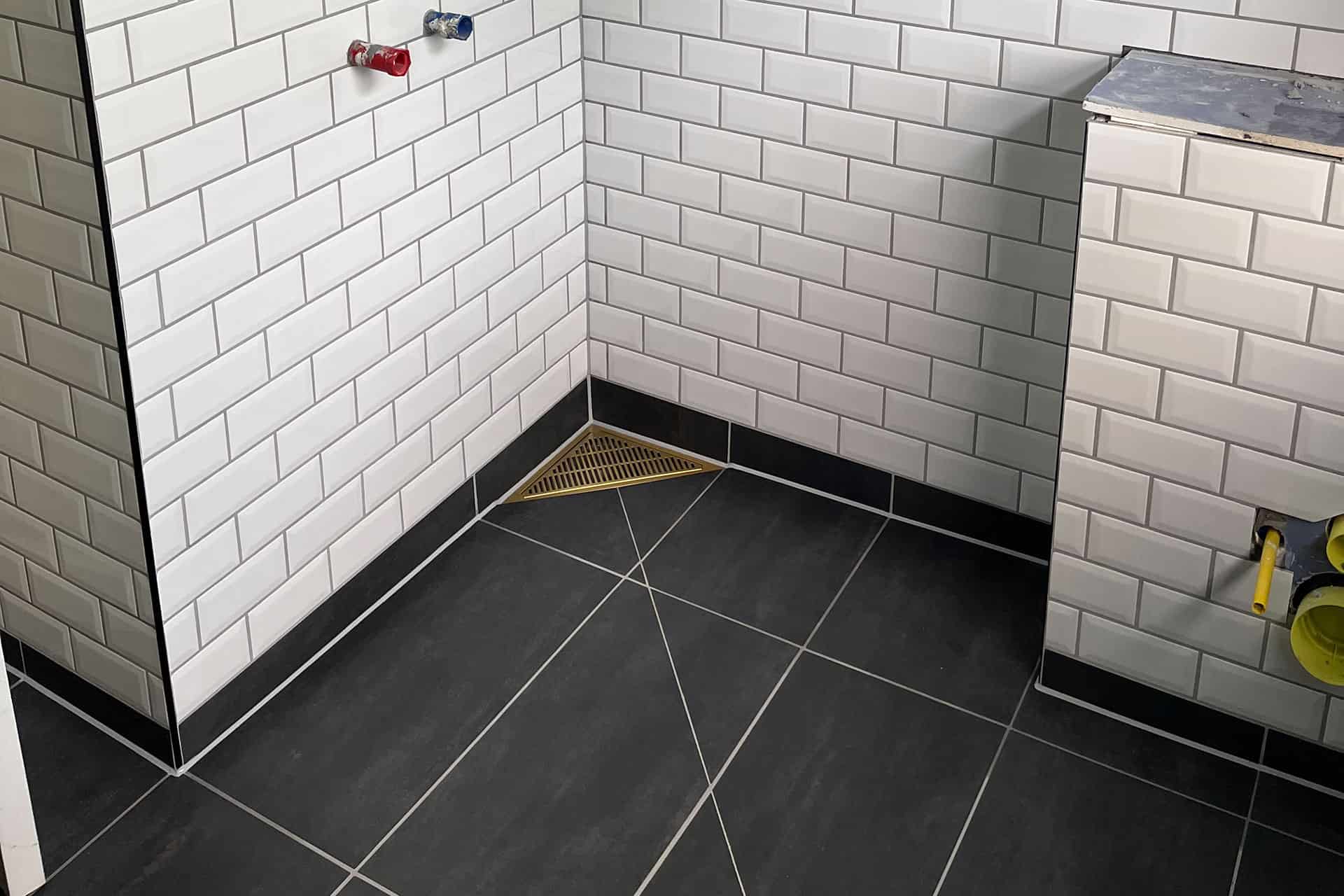 Nærbillede af flisearbejde med hvide klinker i badeværelse