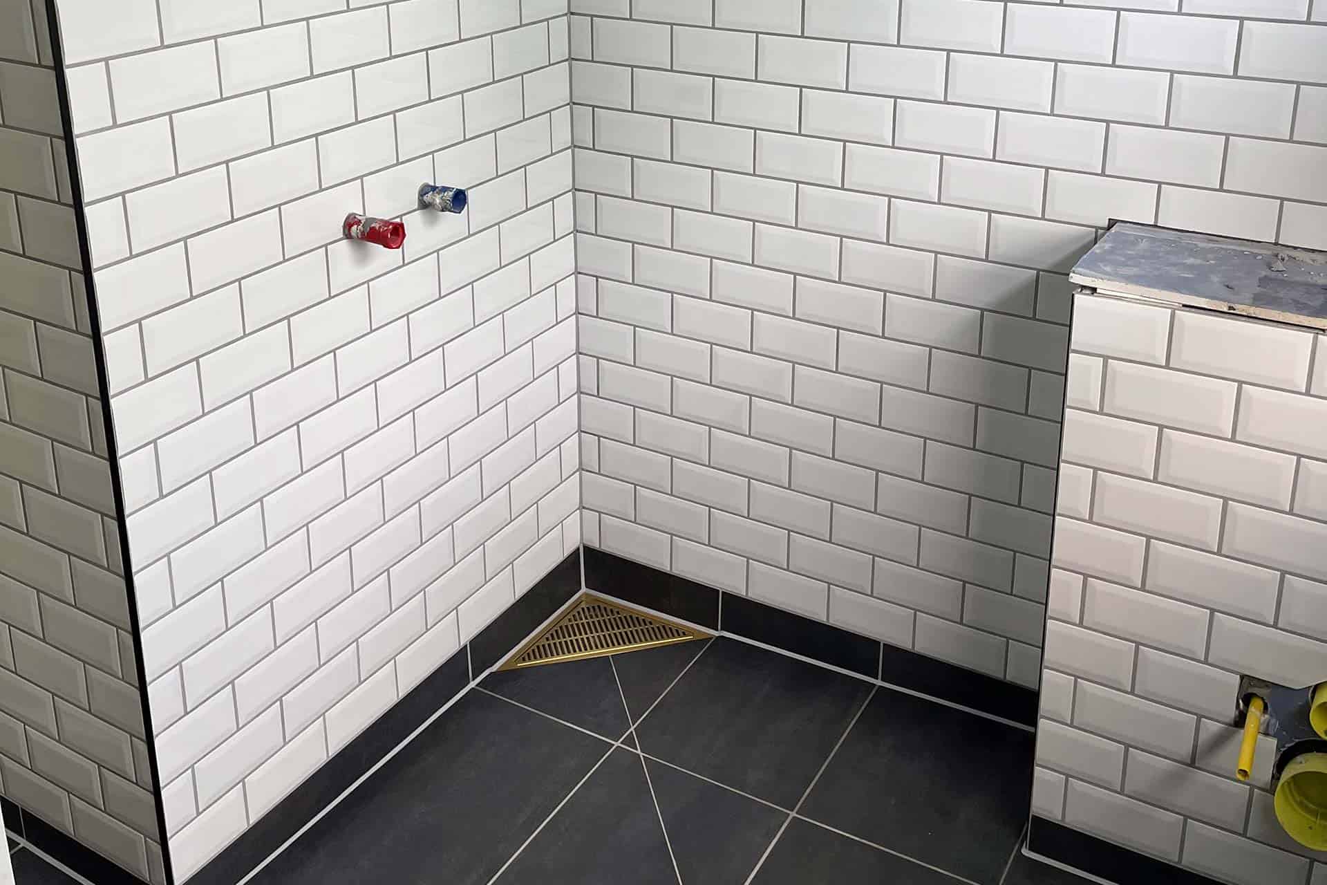 Badeværelse Hvide fliser med mørke fuger i badeværelse udført i fagentreprise
